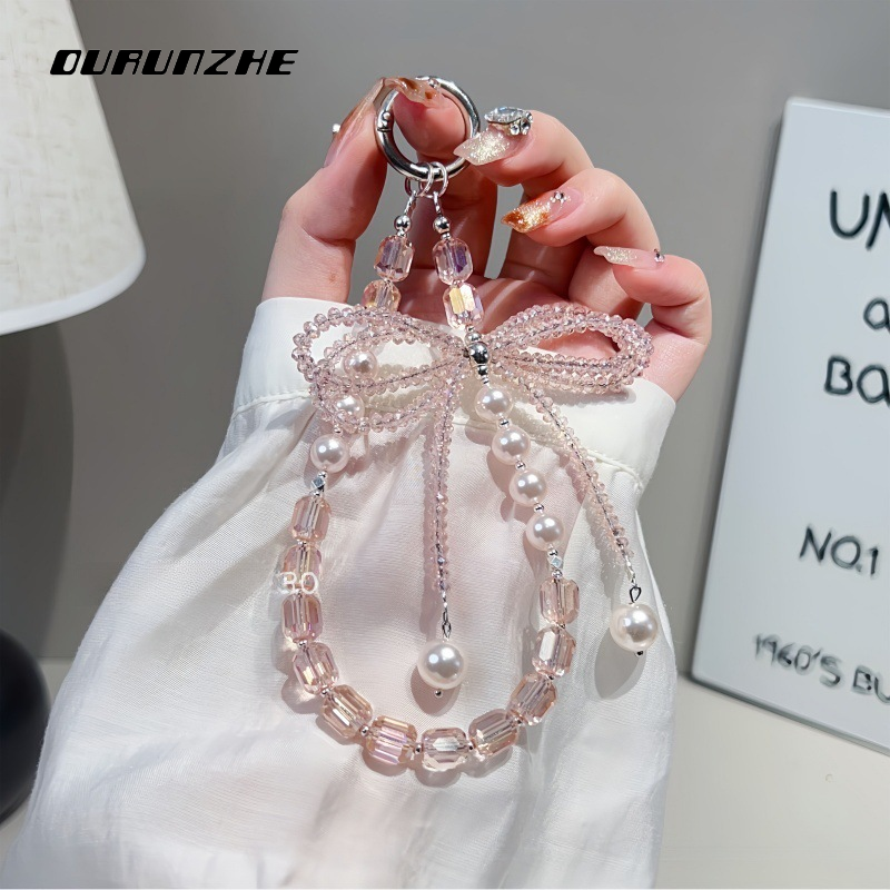 OURUNZHE เครื่องประดับห้อยโทรศัพท์คริสตัลและไข่มุกหรูหราแบบโบว์ สร้อยข้อมือแฟชั่นสำหรับผู้หญิงและผู้ชาย ราคา 58 บาท*ส่งฟรี